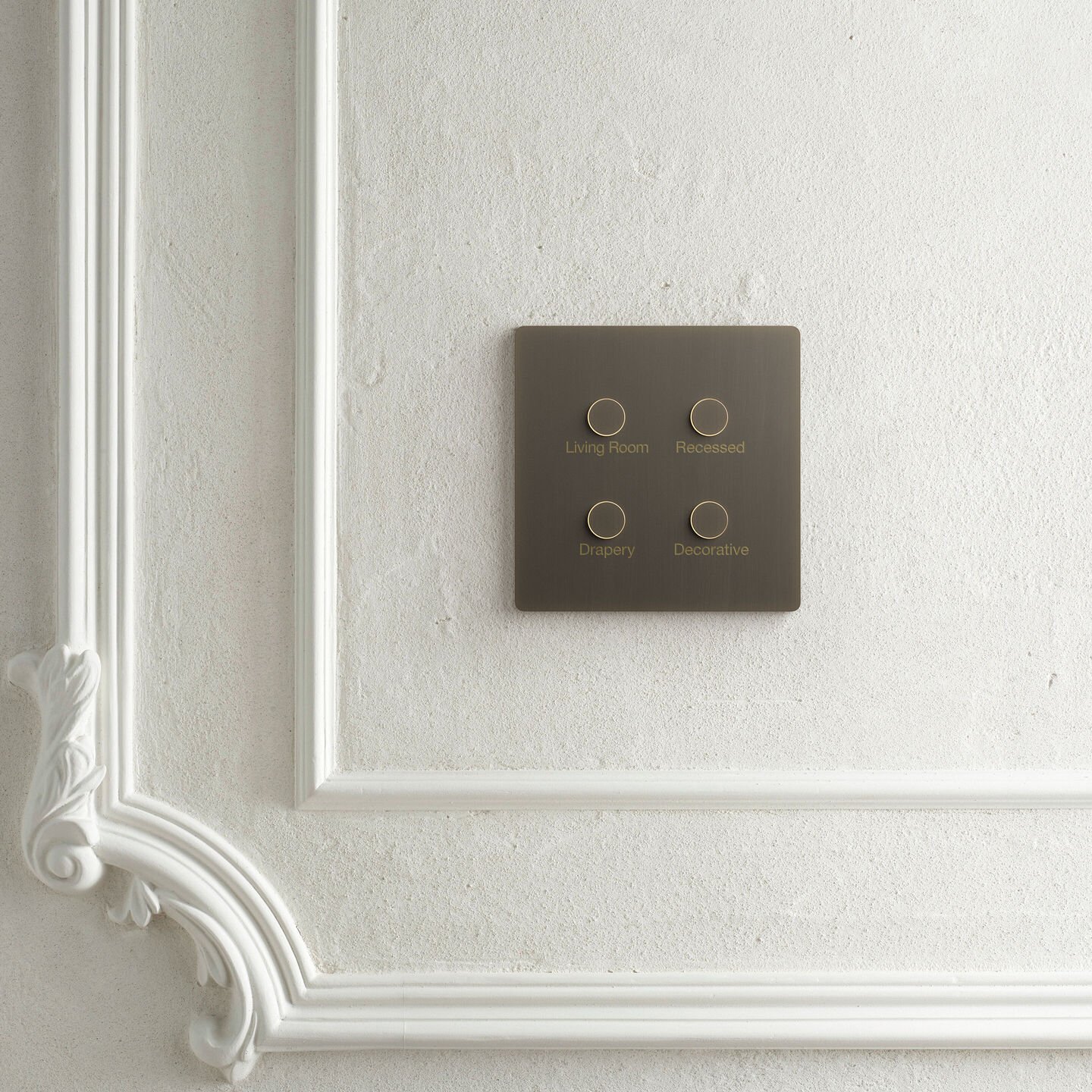 Brass Lutron Alisse four-button keypad on a paneled wall
